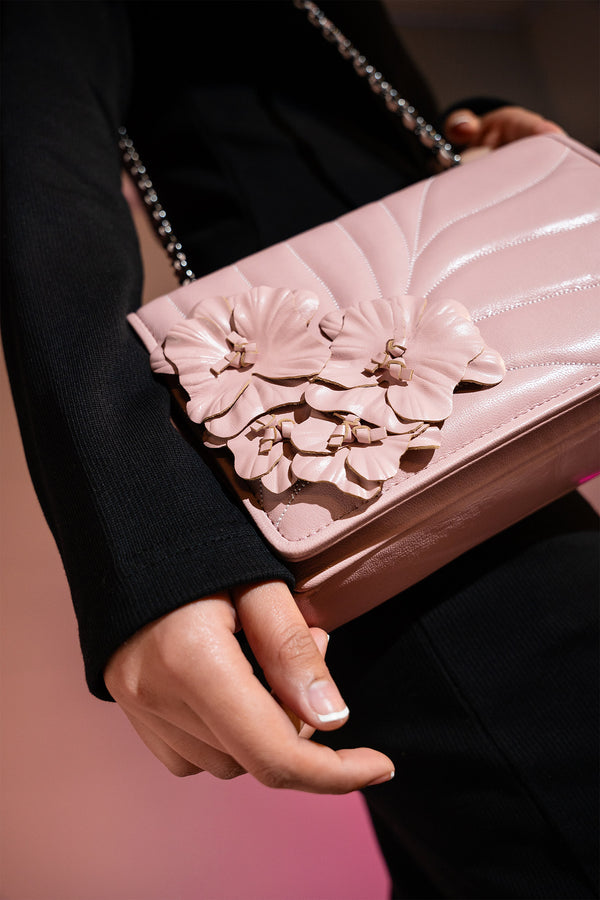 Women's leather shoulder bag in light pink colour with quilting and leatherette flower brooch by JULKE. 