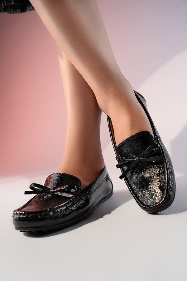 Women's winter leather moccasins in black colour with glossy finish and leather bow by JULKE