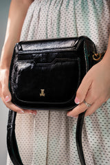 Womens leather shoulder bag in black colour with old horsebit buckle and metallic button flap by JULKE