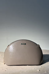 Women's leather travel makeup pouch in grey colour in semi-circle shape with detachable chain strap by JULKE