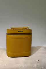 Women's leather cosmetics vanity trunk in mustard yellow colour with gold metallic chain handle  by JULKE