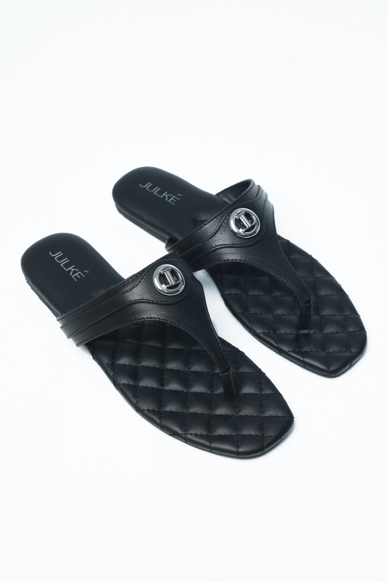 Womens leather flat thongs in black colour with quilted insock and metal logo by JULKE